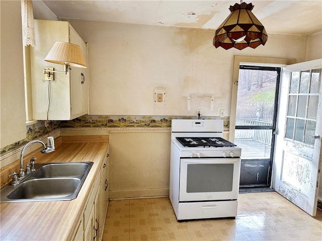 kitchen featuring white range with gas stovetop and sink