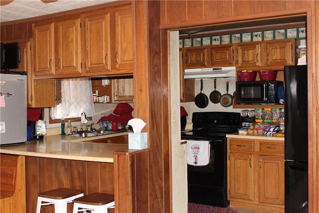 567 Klein Rd, Mill Creek, PA 16145 - kitchen featuring under cabinet range hood, a sink, brown cabinets, and black appliances