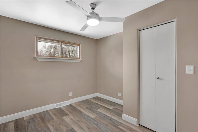 unfurnished bedroom with ceiling fan, a closet, and light hardwood / wood-style flooring