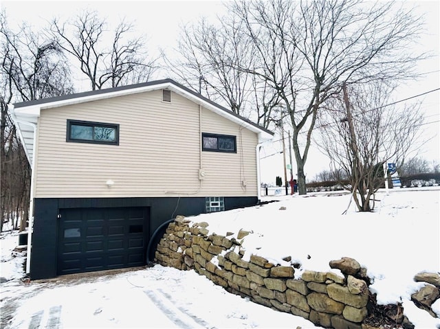 view of snow covered exterior with a garage