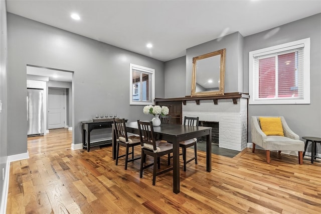 dining area with a fireplace and light hardwood / wood-style flooring