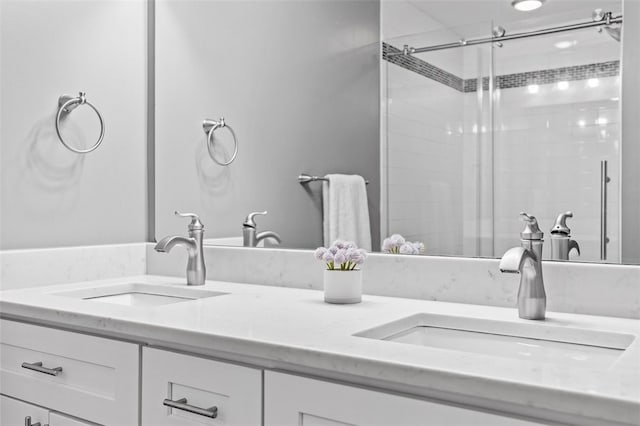 bathroom featuring a shower with door and vanity