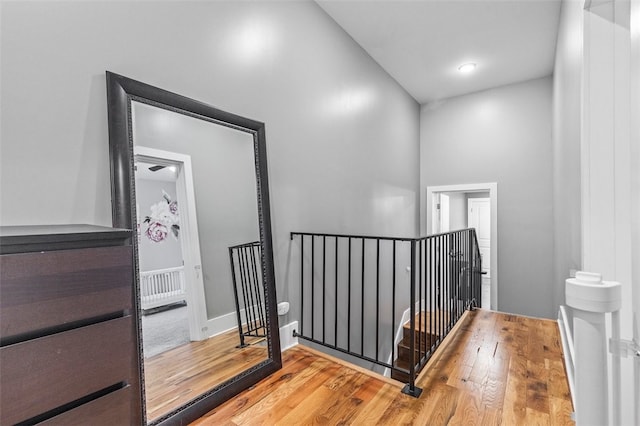 hallway featuring a towering ceiling and hardwood / wood-style flooring