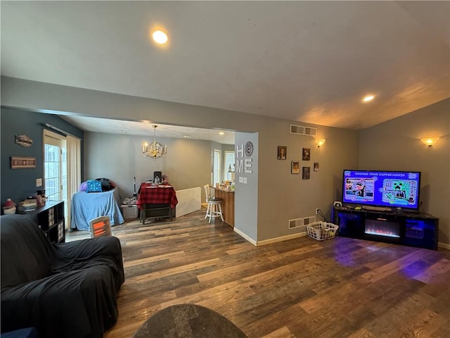 living room with a notable chandelier and hardwood / wood-style flooring