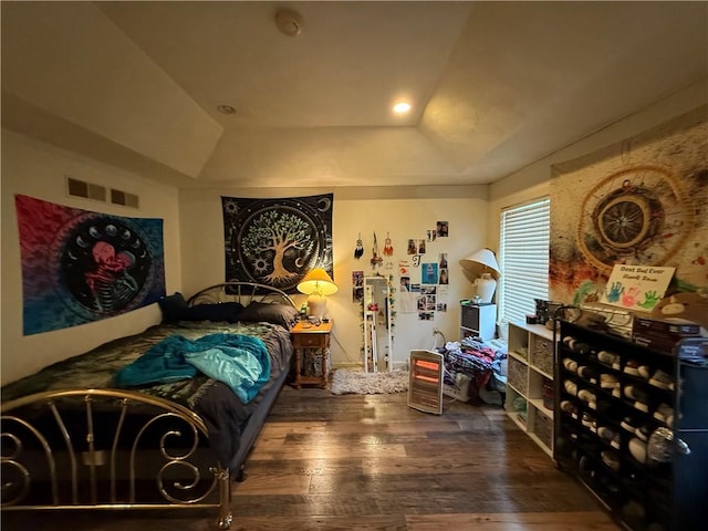 bedroom featuring a tray ceiling and dark wood-type flooring