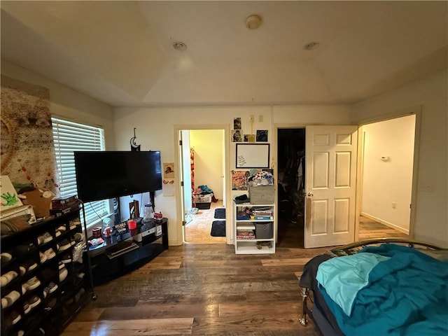 bedroom with lofted ceiling, a closet, and dark hardwood / wood-style flooring