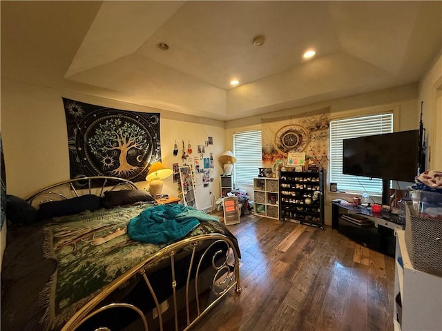 bedroom featuring a raised ceiling and dark wood-type flooring