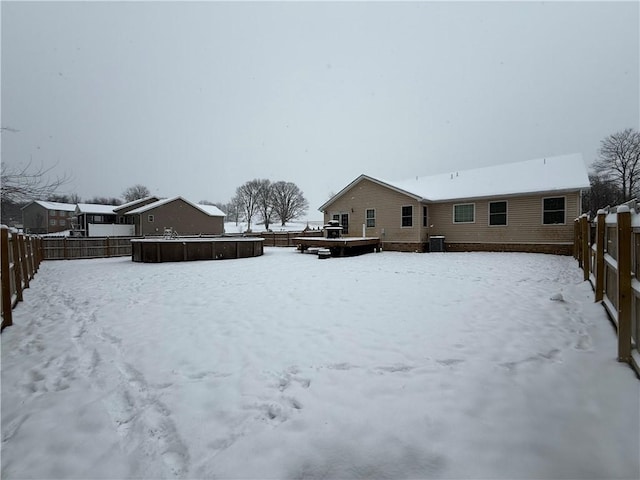 snowy yard with a swimming pool and central AC unit