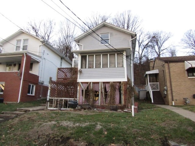 view of front of house featuring a front yard and a sunroom