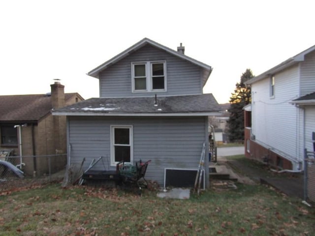 rear view of property featuring a lawn