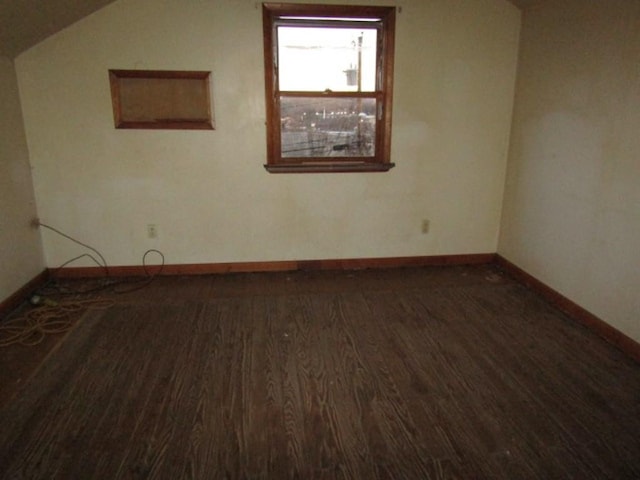 unfurnished room with dark hardwood / wood-style flooring and lofted ceiling