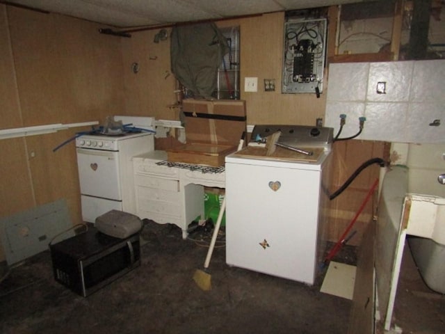 interior space with separate washer and dryer, wood walls, and white stove