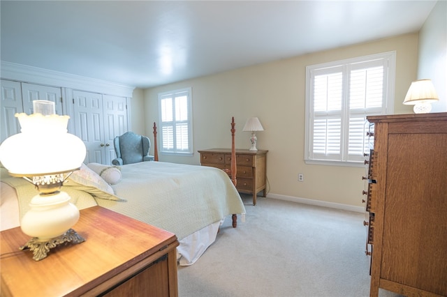 carpeted bedroom with a closet and multiple windows