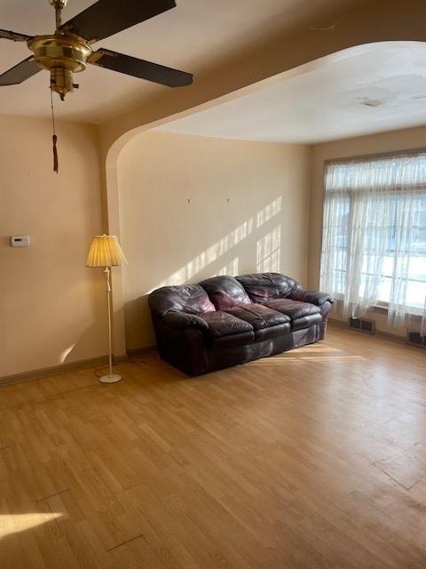 living room with wood-type flooring and ceiling fan