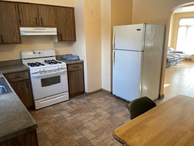 kitchen with sink, white appliances, and ventilation hood