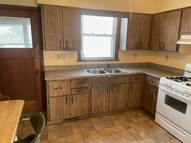 kitchen featuring sink, white range with gas cooktop, and plenty of natural light