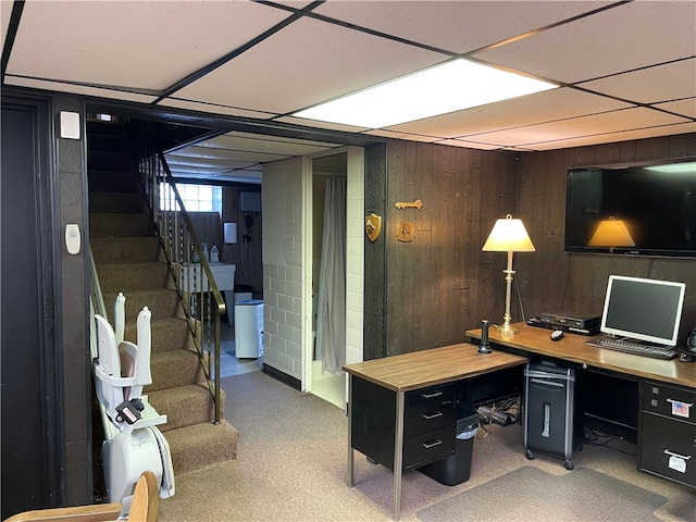 office featuring a drop ceiling and wooden walls