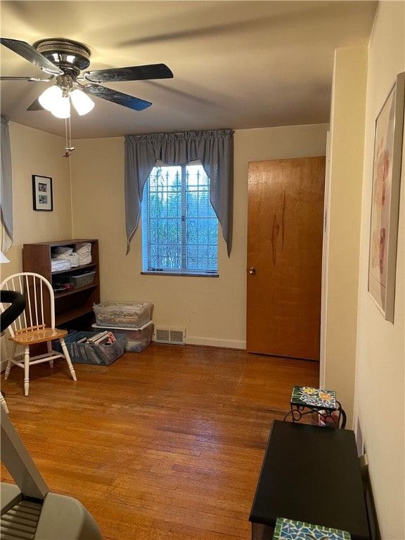 sitting room with ceiling fan and hardwood / wood-style flooring