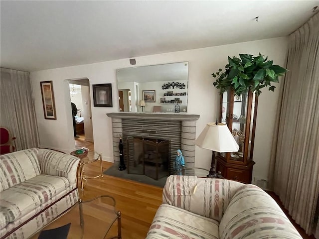 living room featuring hardwood / wood-style floors and a stone fireplace