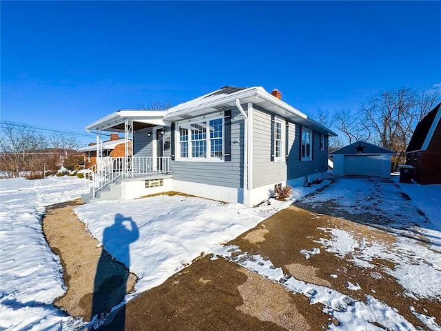 view of front of property featuring a garage and an outdoor structure