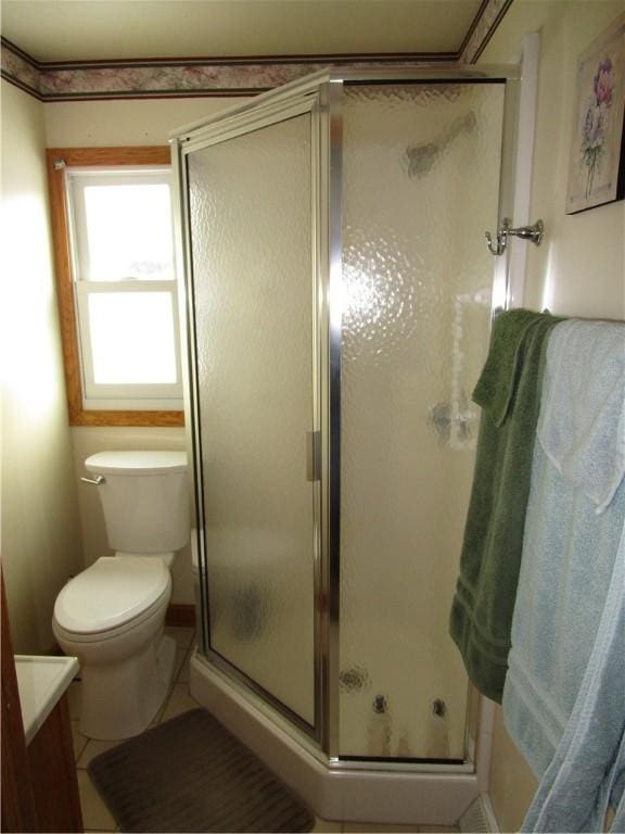 bathroom featuring toilet, tile patterned flooring, walk in shower, and vanity