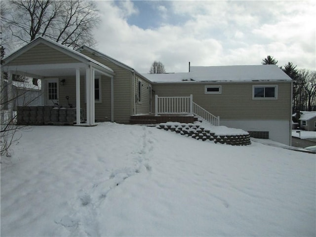 snow covered rear of property with a porch