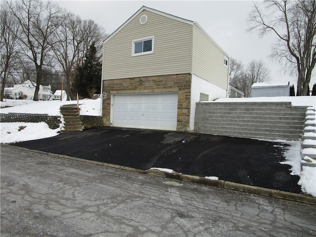 snow covered property with a garage