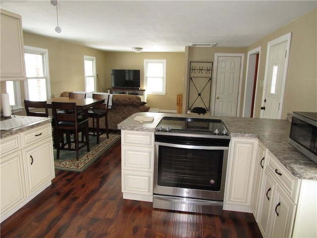 kitchen featuring light stone counters, stainless steel appliances, and dark wood-type flooring