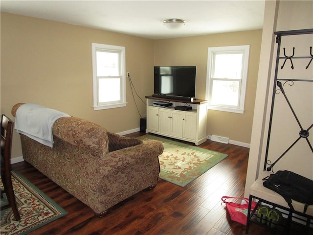 living room with dark hardwood / wood-style flooring and plenty of natural light