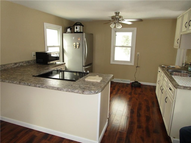 kitchen with kitchen peninsula, ceiling fan, stainless steel fridge, and sink