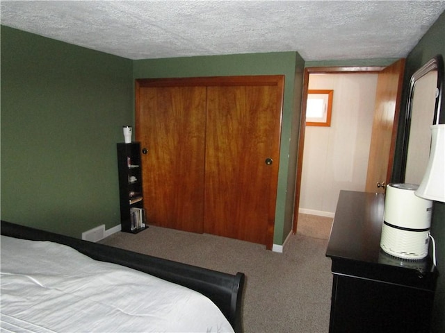 bedroom featuring a closet, a textured ceiling, and carpet floors