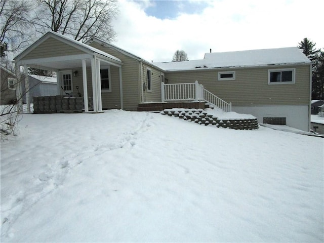 snow covered house featuring covered porch