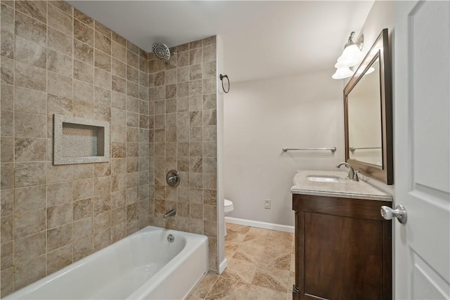 full bathroom featuring toilet, tiled shower / bath combo, and vanity