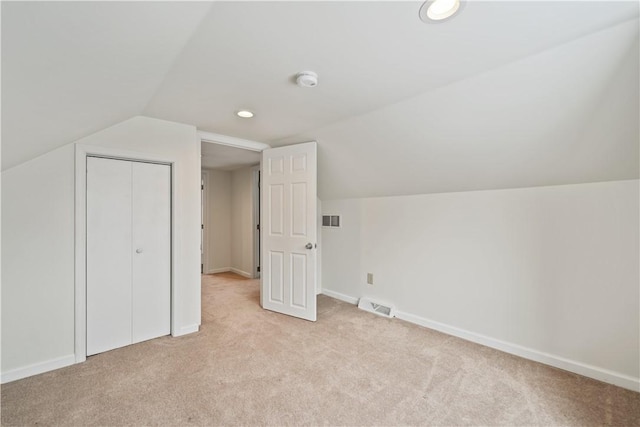 additional living space with light colored carpet and vaulted ceiling