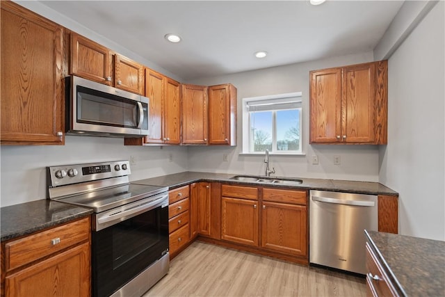 kitchen featuring stainless steel appliances, light hardwood / wood-style flooring, and sink