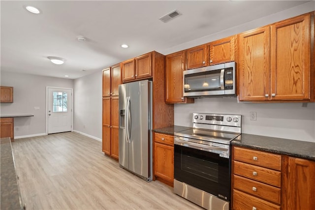 kitchen with stainless steel appliances and light hardwood / wood-style flooring