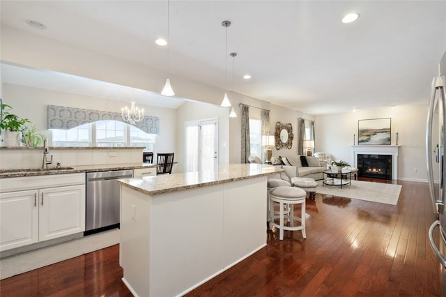 kitchen featuring sink, white cabinetry, dishwasher, and hanging light fixtures