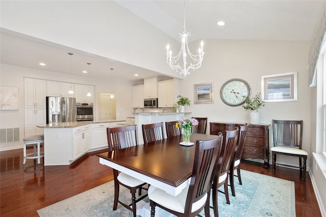 dining space with high vaulted ceiling, an inviting chandelier, and dark hardwood / wood-style floors