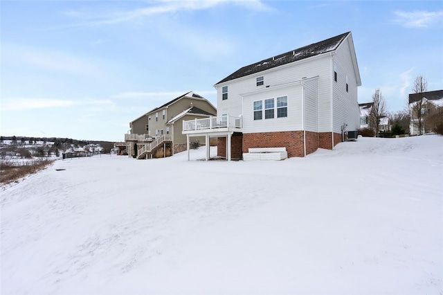 snow covered property featuring central AC and a wooden deck