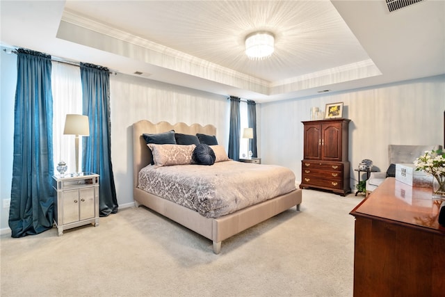 bedroom with multiple windows, a tray ceiling, and light colored carpet