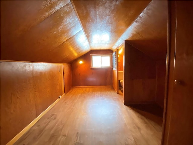 bonus room with light hardwood / wood-style flooring and lofted ceiling