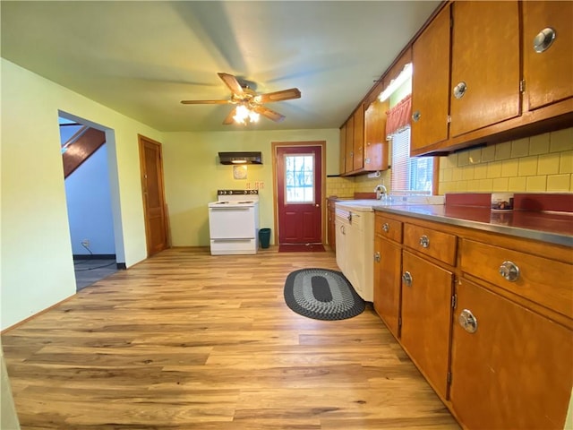 kitchen featuring white range with electric cooktop, light wood-type flooring, ceiling fan, sink, and backsplash