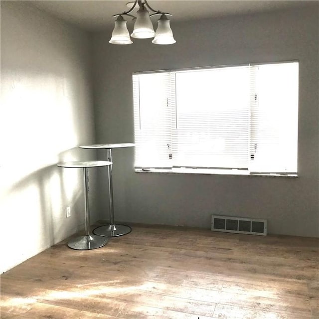 interior space with wood-type flooring and a chandelier