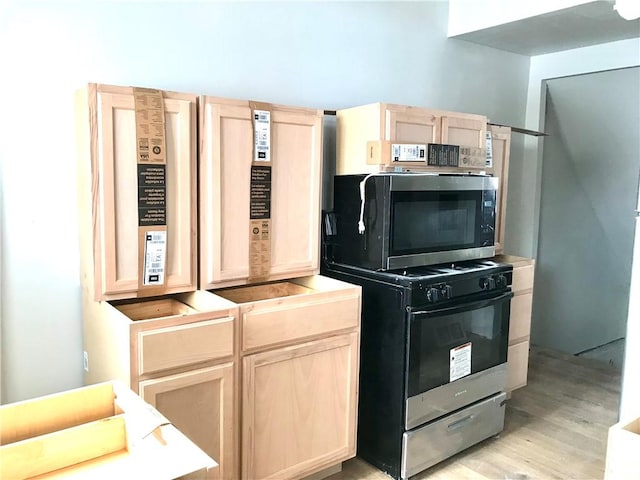 kitchen with light wood-type flooring, range, and light brown cabinets