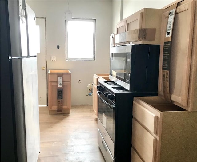 kitchen with light wood-type flooring, light brown cabinetry, and stainless steel refrigerator