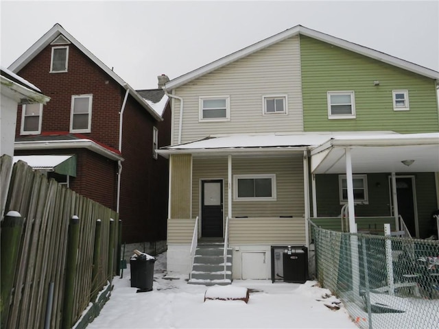 snow covered house featuring a porch