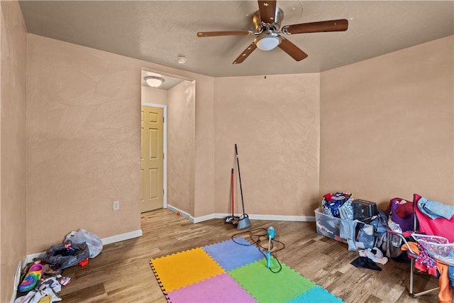 exercise area featuring ceiling fan and wood-type flooring