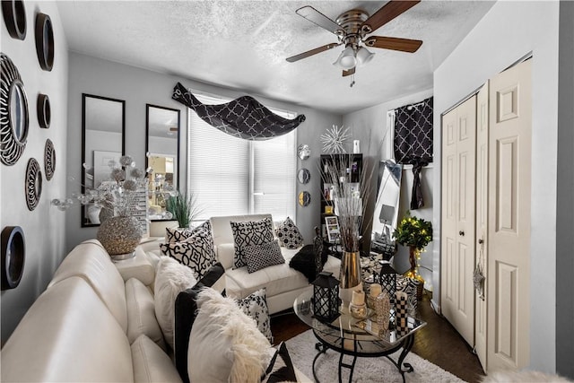 living room featuring a textured ceiling, ceiling fan, and hardwood / wood-style flooring