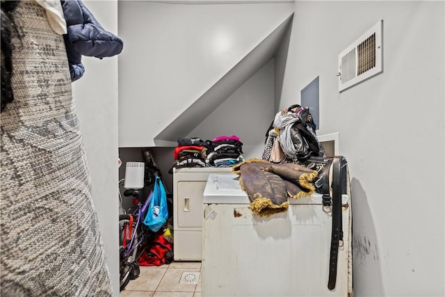 clothes washing area featuring light tile patterned floors and separate washer and dryer