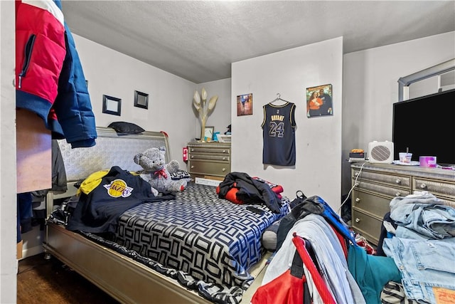 bedroom featuring a textured ceiling and dark hardwood / wood-style floors